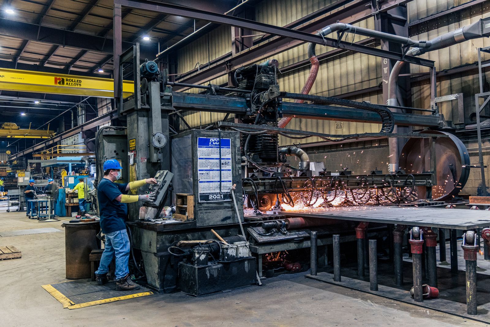 Metal üretim tesisinde çalışan operatör ve üretim makineleri
